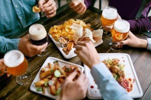 men drinking beer and eating food closeup